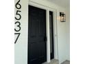 Modern black front door with sidelight and house number at 6537 Everett St, Arvada, CO 80004