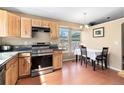 Sunlit kitchen features wood cabinets, stainless steel appliances, and a dining area with natural lighting at 12418 Albion St, Thornton, CO 80241