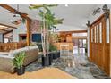 Open living space with wood beam ceilings, brick accents, and indoor plants, creating a nature-filled ambiance at 8280 Queen St, Arvada, CO 80005