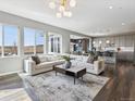 Bright, open-concept living area with hardwood floors and large windows offer scenic views at 11426 Box Turtle Ct, Parker, CO 80134