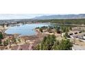 Scenic aerial view of the community featuring a lake, trees, and mountain views at 1890 Bel Lago Vw, Monument, CO 80132