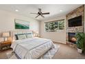 Beautiful bedroom with a stone fireplace, ceiling fan and large windows at 1890 Bel Lago Vw, Monument, CO 80132