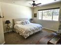 Bright bedroom featuring a comfortable king-sized bed, ceiling fan, and a sun-filled window at 1890 Bel Lago Vw, Monument, CO 80132