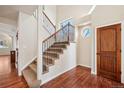 Inviting foyer features a staircase with iron railings and hardwood floors at 1890 Bel Lago Vw, Monument, CO 80132
