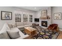 Inviting living room with stone fireplace, large windows, and a stylish accent rug at 15784 Burrowing Owl Ct, Morrison, CO 80465