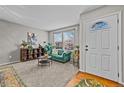 Cozy living room with plants, a large window, an emerald couch, and stylish décor at 5535 S Rome St, Aurora, CO 80015