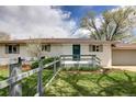Lovely home showcasing a quaint front porch, well-maintained lawn and fence for added curb appeal at 4972 Easley Rd, Golden, CO 80403