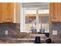 Beautiful kitchen view featuring granite countertops and wooden cabinetry looking out over the pasture at 4972 Easley Rd, Golden, CO 80403