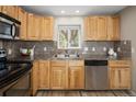 Well-lit kitchen with light wood cabinets, stainless steel appliances and decorative backsplash tiles at 4972 Easley Rd, Golden, CO 80403