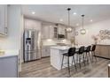 Modern kitchen with stainless steel appliances, gray cabinets, pendant lighting and island with seating at 431 Courtfield Way, Castle Pines, CO 80108