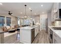 Open-concept kitchen with island, stainless steel appliances, flows into the living and dining areas at 431 Courtfield Way, Castle Pines, CO 80108