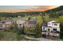 A well-kept home with a spacious deck overlooks a grassy, wooded lot at sunset at 24005 High Meadow Dr, Golden, CO 80401