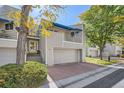 Gray townhouse exterior with a two-car garage and landscaping at 9200 E Cherry Creek South Dr # 10, Denver, CO 80231
