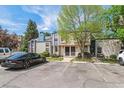 Exterior view of townhome with parking; features mature trees, blue and pink trim, and walkway at 16104 E Alaska Pl # D, Aurora, CO 80017