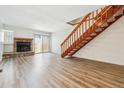 Inviting living room with a stone fireplace, wood-look flooring, and a stairway to the upper level at 16104 E Alaska Pl # D, Aurora, CO 80017