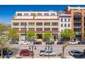 Full front exterior showcasing a well-maintained building with mature trees, a sunny blue sky, and street-level parking at 1435 Wazee St # 504, Denver, CO 80202