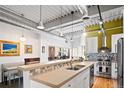 Open kitchen with breakfast bar and stainless steel appliances, and an industrial-style ceiling and pendant lighting at 1435 Wazee St # 504, Denver, CO 80202