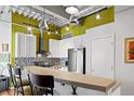 Modern kitchen with stainless steel appliances, white cabinets, bar seating and an industrial ceiling at 1435 Wazee St # 504, Denver, CO 80202