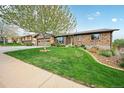 Charming brick home with a well-manicured lawn, mature trees, and an attached two car garage at 2140 S Coors Cir, Lakewood, CO 80228