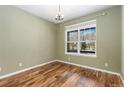 Bright bedroom with hardwood floors and a window overlooking the snow covered neighborhood at 2112 Springs Pl, Longmont, CO 80504