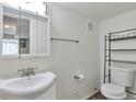 Small, plain bathroom with a sink, toilet, mirror, and minimal decor at 3792 S Pitkin Ct, Aurora, CO 80013
