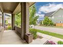Inviting covered porch featuring brick columns and plenty of space for outdoor seating at 8768 E 54Th Pl, Denver, CO 80238
