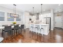 Bright kitchen featuring white cabinets, stainless steel appliances and a modern island with seating at 8768 E 54Th Pl, Denver, CO 80238