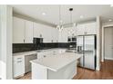 Stylish kitchen boasting white cabinets, stainless steel appliances, a large island, and sleek black countertops at 1559 N Hooker St, Denver, CO 80204