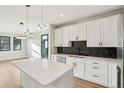 Modern kitchen featuring a large island, stainless steel appliances, white cabinets, and hardwood flooring at 1559 N Hooker St, Denver, CO 80204