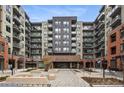 Contemporary condominium complex featuring balconies and a brick entryway with 'Encore' signage at 20 Wilcox St # 208, Castle Rock, CO 80104