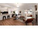 Bright living room featuring wood floors, modern furnishings, and access to the outdoors through sliding glass doors at 8422 Everett Way # D, Arvada, CO 80005