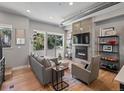 Cozy living room with a modern fireplace, mounted TV, sliding door access to a deck, and hardwood floors at 2833 W 25Th Ave # 5, Denver, CO 80211