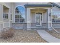 Inviting home exterior featuring a charming front entrance with stone accents and a well-lit porch at 9742 E Hawaii Pl, Aurora, CO 80247