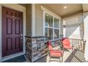 Inviting front porch with stone accents, decorative lattice, and comfortable seating for relaxing outdoors at 15979 Xanthia Way, Thornton, CO 80602