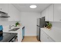 Modern kitchen with white cabinets, blue accents, and quartz countertops at 3369 S Monaco Street Pkwy # A, Denver, CO 80222