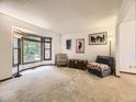 Bright living room featuring a bay window, neutral carpet, and comfortable seating arrangements at 3210 S Espana Cir, Aurora, CO 80013