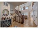 Bright entryway with beautiful hardwood floors and a wooden staircase leading to the second floor and open living area at 27185 E Costilla Dr, Aurora, CO 80016