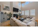 Cozy living room with a fireplace, large windows, and a comfortable sectional sofa for relaxing and entertaining at 27185 E Costilla Dr, Aurora, CO 80016