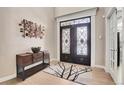 Elegant entryway with double doors and wood flooring at 5965 Topaz Vista Pl, Castle Pines, CO 80108