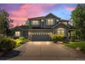 Attractive two-story home with professional landscaping and a wide driveway at dusk at 15904 W 58Th Ave, Golden, CO 80403