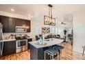 Modern kitchen features dark cabinetry, stainless steel appliances, a stylish island, and an open concept layout at 2426 S Acoma St, Denver, CO 80223