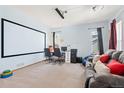 Finished basement featuring a large projector screen, workspace, and comfortable seating area, perfect for entertainment at 13131 Pennsylvania St, Thornton, CO 80241