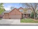 Charming two-story brick home featuring a three-car garage, covered porch, and well-maintained front yard at 13131 Pennsylvania St, Thornton, CO 80241