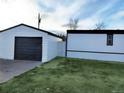 White detached garage with dark gray door at 102 Jackson Dr, Firestone, CO 80520