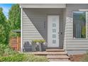 Modern front entrance with white door and gray siding at 4937 Tamarac St, Denver, CO 80238