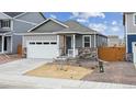 Gray exterior ranch home with a two-car garage and stone accents at 827 Ledge St, Lochbuie, CO 80603