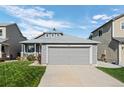 View of charming gray home featuring an attached garage, well-maintained lawn, and blue sky at 8761 Cloverleaf Cir, Parker, CO 80134