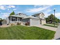 Charming home featuring a well-manicured front yard, colorful flowers, and an attached two-car garage at 8761 Cloverleaf Cir, Parker, CO 80134