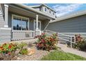 Beautifully landscaped front yard with a charming covered porch and colorful flower bushes at 8761 Cloverleaf Cir, Parker, CO 80134