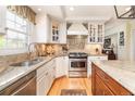 Bright kitchen featuring custom cabinetry, granite countertops, stainless steel appliances, and hardwood floors at 6964 S Olive Way, Centennial, CO 80112